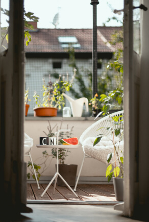Piccolo balcone con piante, tavolino e sedie