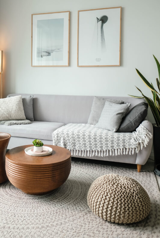Divano letto grigio chiaro con cuscino e coperte in un soggiorno moderno